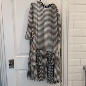Black and white checkered dress. Sheer sleeves. Two ruffles at the bottom.